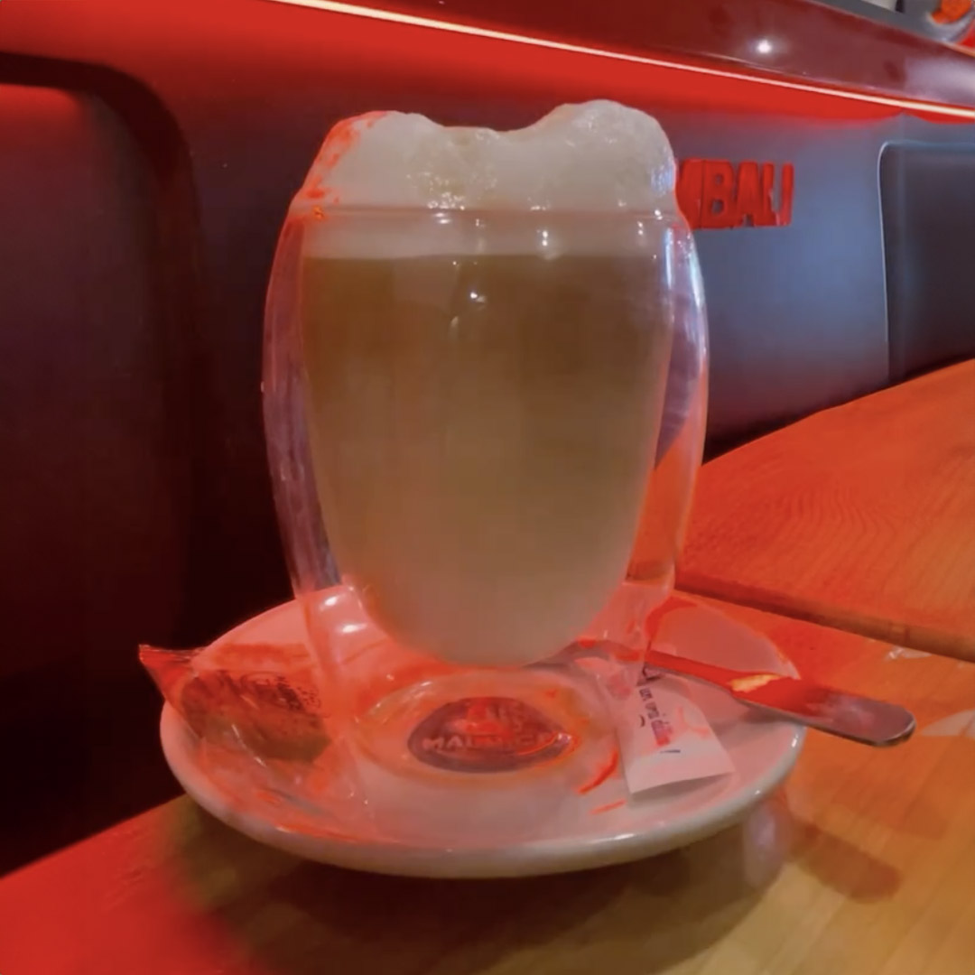 Ice Latte avec une belle mousse, servis dans un verre double paroi.